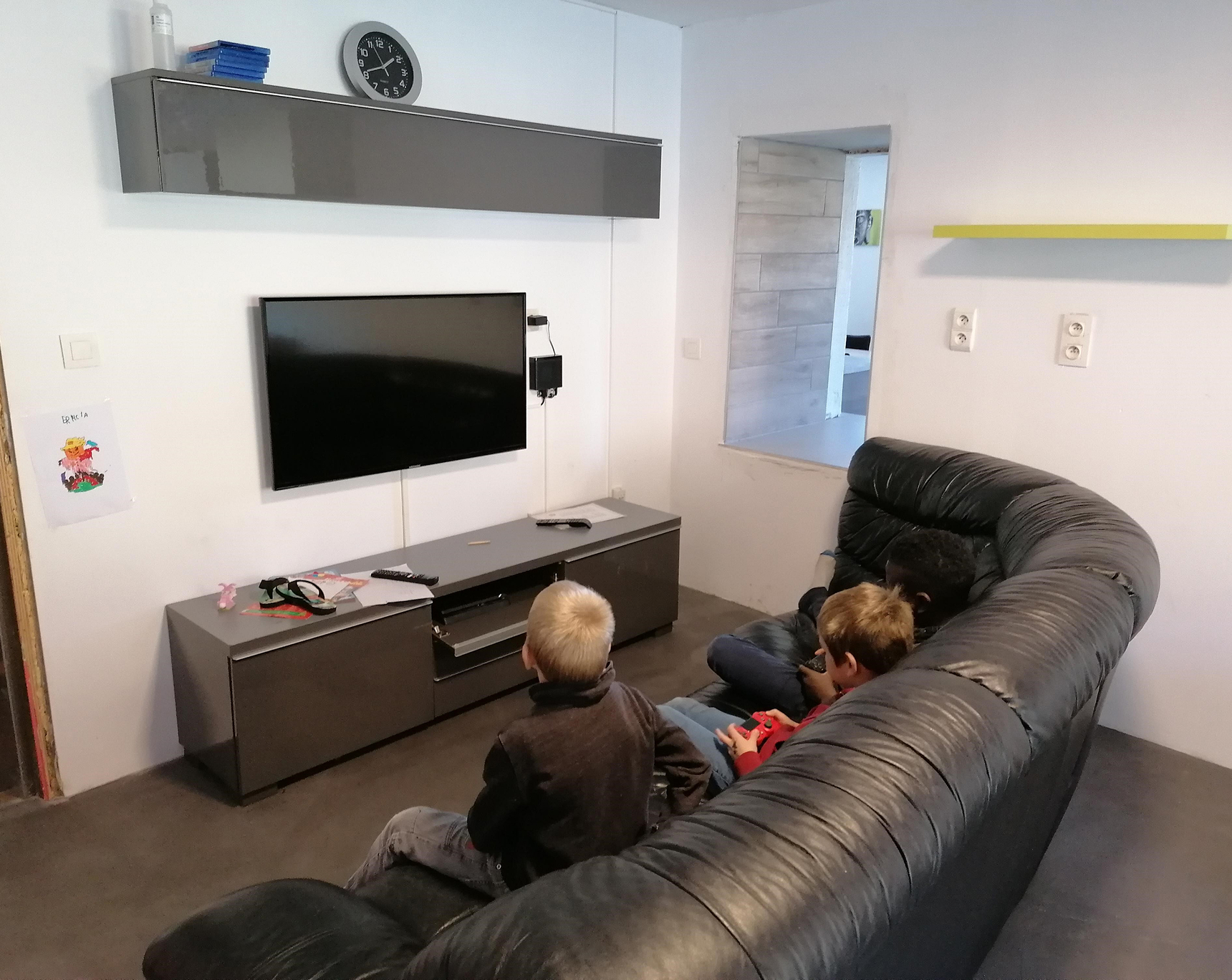 Salon avec des enfants qui jouent à la console