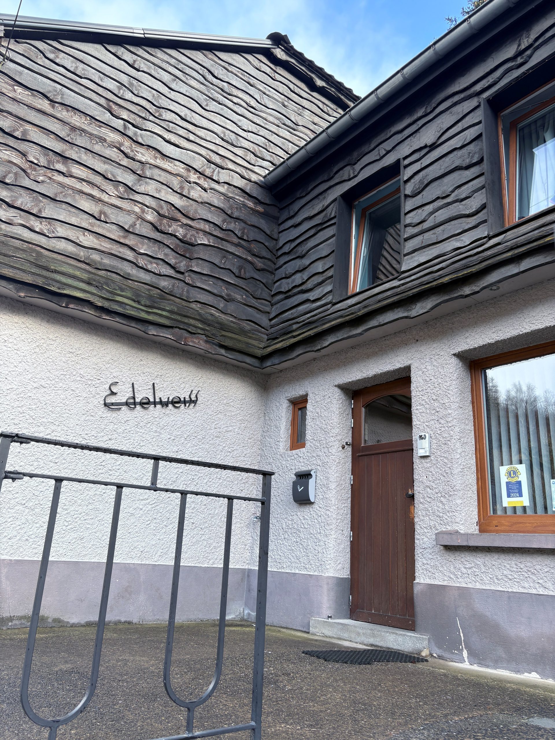 Entrée de la maison avec le nom forgé sur le mur